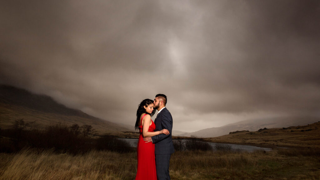 Couple embracing beneath a dramatic sky
